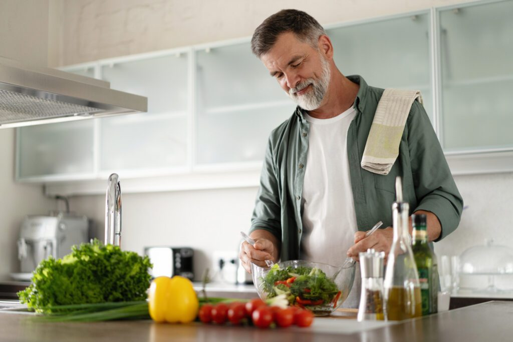 Man preparing a fresh salad in his kitchen